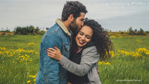 When Your Partner Resists Therapy: Understanding Barriers & Taking Healing Steps 3 Image of a happy couple embracing in a field